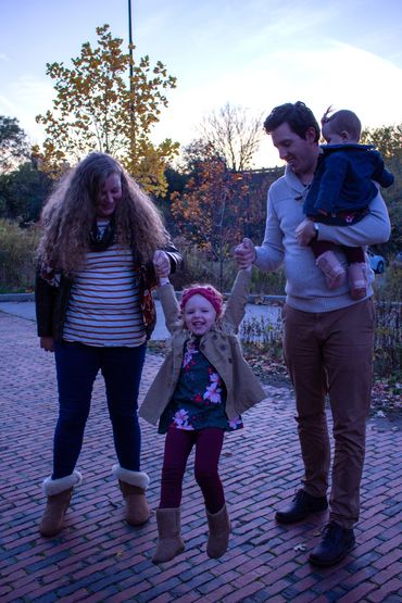 Family enjoying a playful moment outdoors during autumn.
