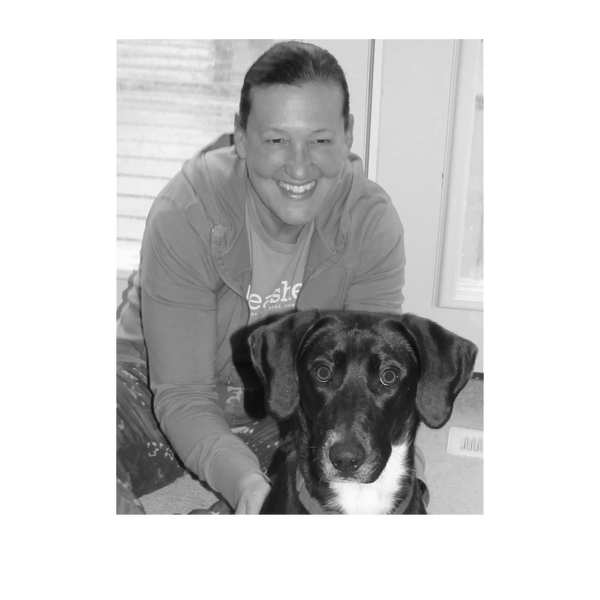 Person sitting on the floor with black and white dog.