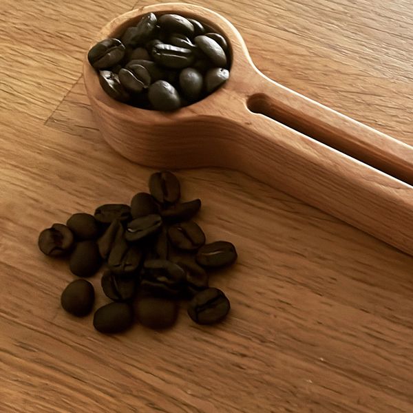 One tablespoon (15 mL)  cherry wood coffee scoop. Made to slide on to a bag of coffee beans.
