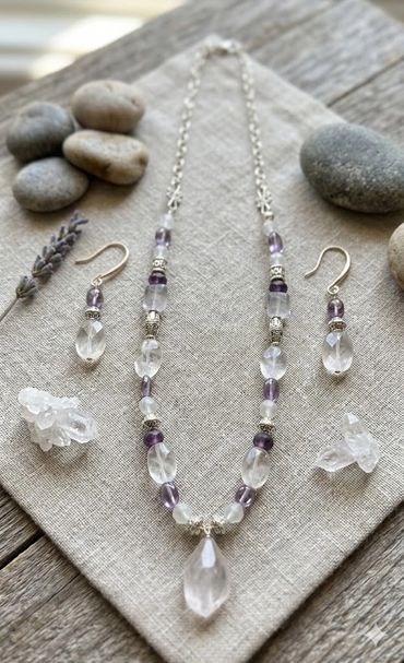 Elegant crystal necklace and earrings set displayed on a linen cloth with stones.