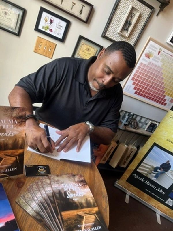 Man signing book at a book signing event.