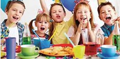 Children celebrating a birthday party with balloons and party hats.
