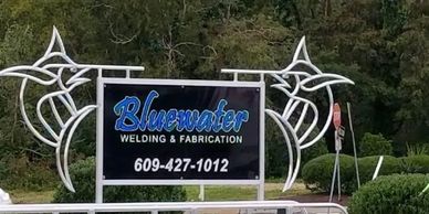 Sign for Bluewater Welding & Fabrication with decorative metal art.