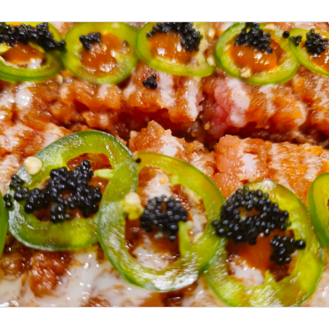 Close-up of spicy food with jalapeños and black caviar.