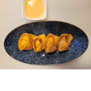Four fried dumplings on a blue plate with dipping sauce.