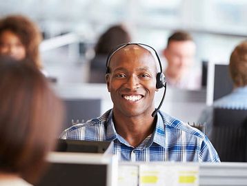 Smiling call center employee wearing headset.
