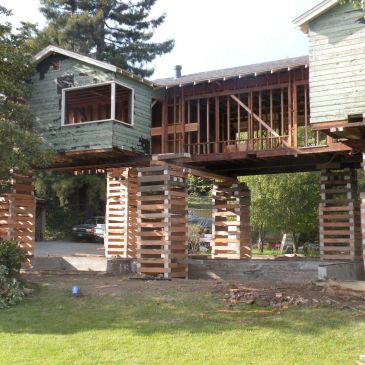House elevated on stacked wooden supports.