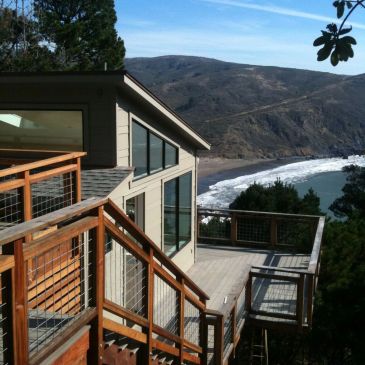 Modern house with ocean view and wooden deck.