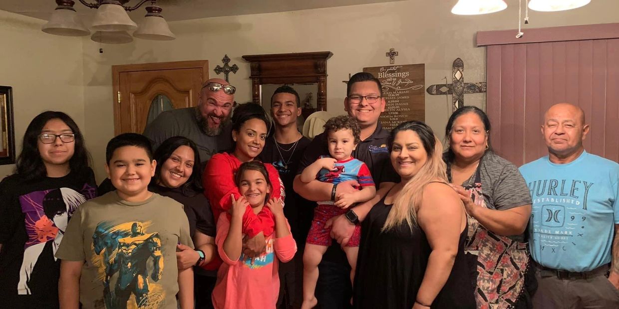 Large family gathering smiling for a group photo indoors.