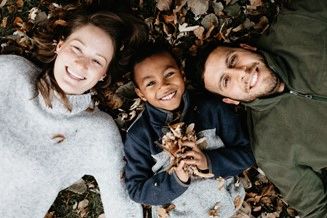 Family laying down on leaves 