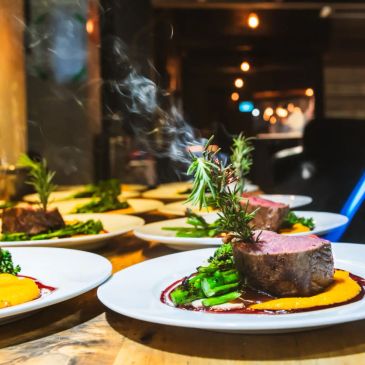 Plated gourmet steak with asparagus and sauce.