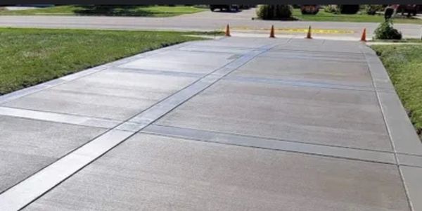 A freshly poured and finished concrete driveway features clean lines, and smooth texture.