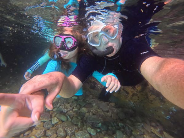 Two people snorkeling underwater taking a selfie.