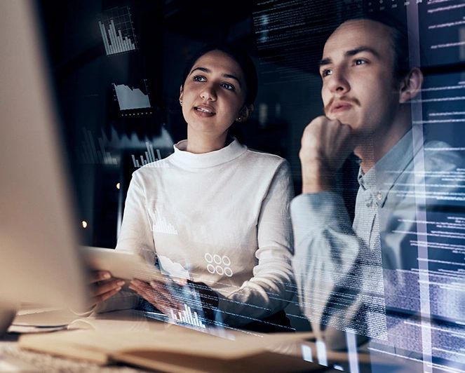 Dos personas analizan datos en una pantalla digital.