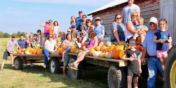 Group of people on wagons with pumpkins
