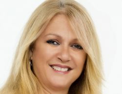 Smiling woman with blonde hair and hoop earrings.