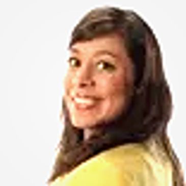 Smiling woman with brown hair wearing a yellow top.