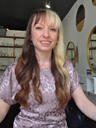 Woman with half blonde, half brown hair sitting in a salon.