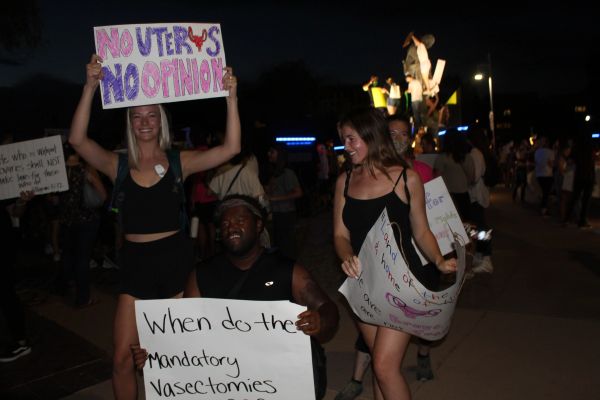 People protesting at night holding various signs.
