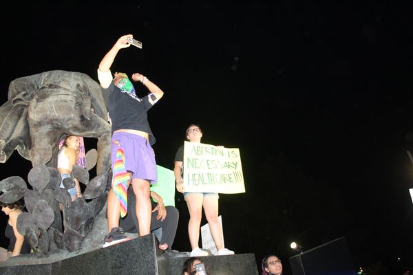 Protesters at night with signs advocating abortion rights.