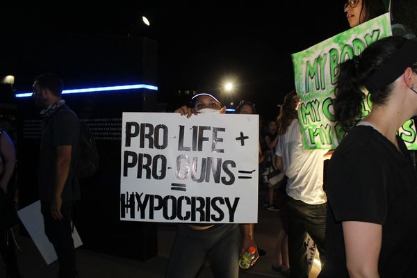 Pro-life and pro-guns protest with signs at night.