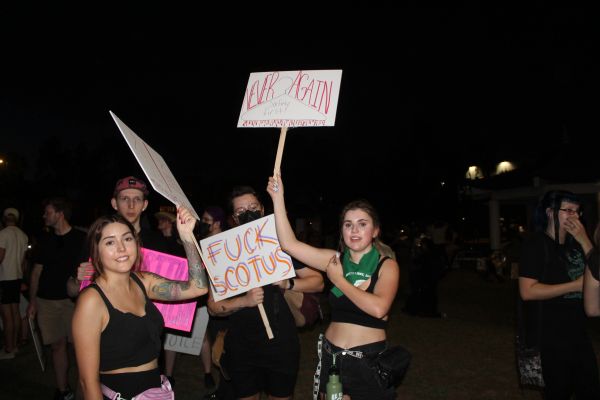 Group of protesters holding signs at night.
