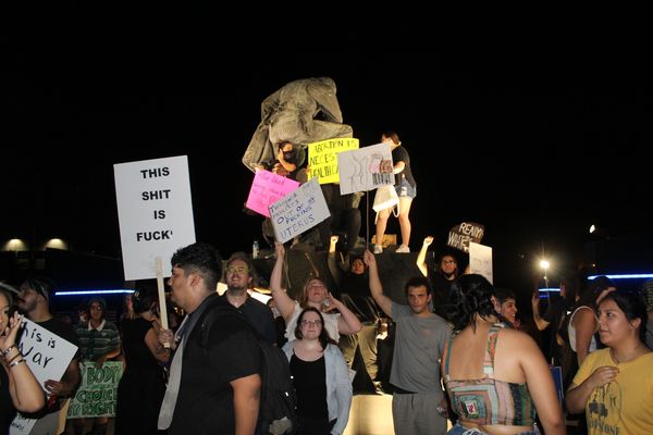 People protesting at night with signs about abortion rights.