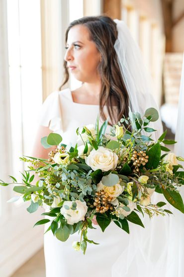 Elegant wedding bouquet with white flowers and heavy greenery