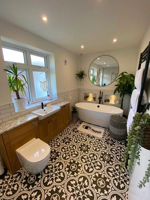 Modern bathroom with patterned floor and freestanding tub.