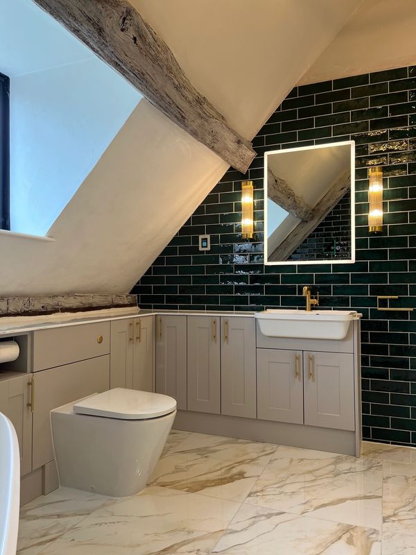Modern bathroom with dark green tiles and wooden beams.