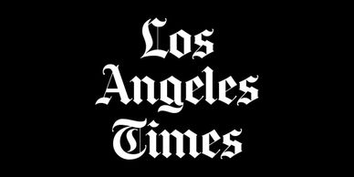 Los Angeles Times logo in blackletter font on black background.