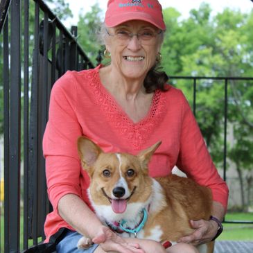 A Woman Sitting on the Stairs With a Corgi