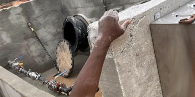 Man in neon yellow shirt pointing at large industrial pipe. Concrete King LLC
