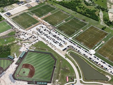 Aerial view of a sports complex with soccer fields and a baseball field.
