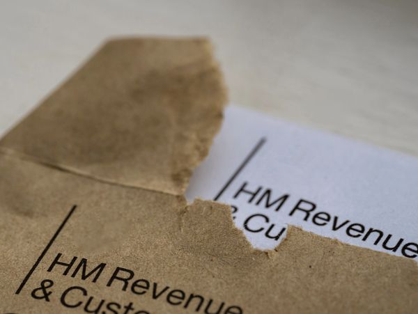 Partially opened HM Revenue &amp; Customs envelope with document inside.