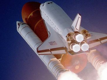 Space Shuttle Atlantis ascending with fiery thrust.