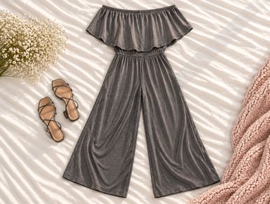 Gray off-shoulder jumpsuit with sandals and cozy blankets.