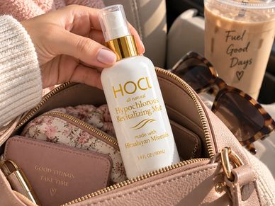 Hand holding HACI Hypochlorous Revitalizing Mist inside a purse.