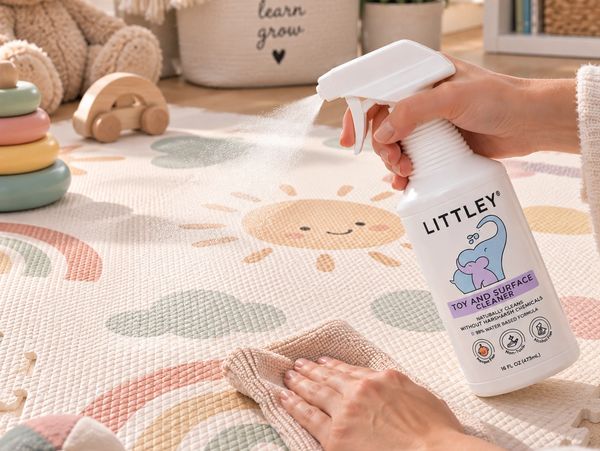 Cleaning a colorful children's play mat with Littley toy and surface cleaner.