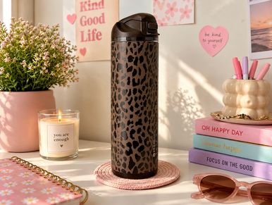 Leopard print tumbler on a cozy desk setup.