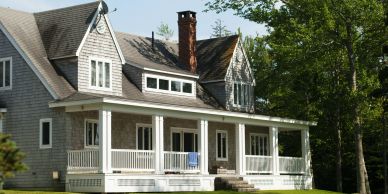 Large house with a porch and chimney.