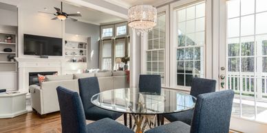 Modern dining area with blue chairs and glass table.