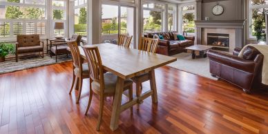 Spacious living and dining area with wooden floors and large windows.