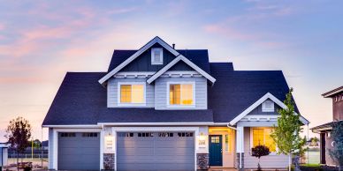 A beautiful modern house at dusk with lights on.