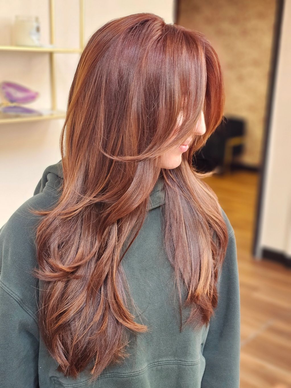 Woman with long, layered reddish-brown hair and side bangs.