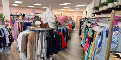 Inside a bright clothing store with racks of colorful clothes.