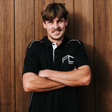 Man standing with arms crossed, smiling.
