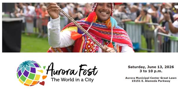 Smiling man in colorful traditional attire at Aurora Fest, 2026.