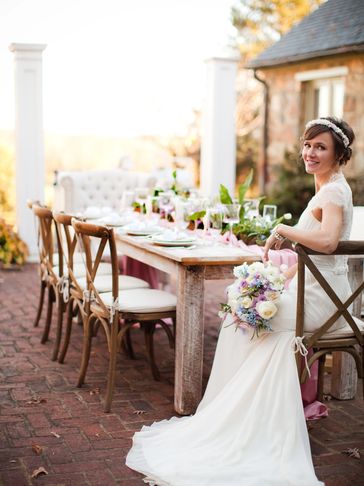 Bride sitting at modern farmhouse decor wedding table