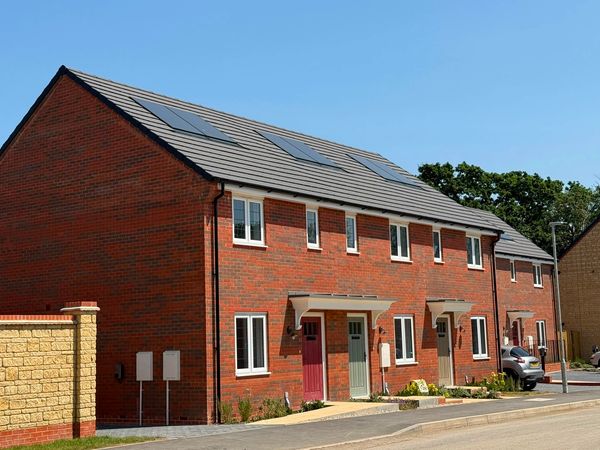 Row of modern brick townhouses on a sunny day.